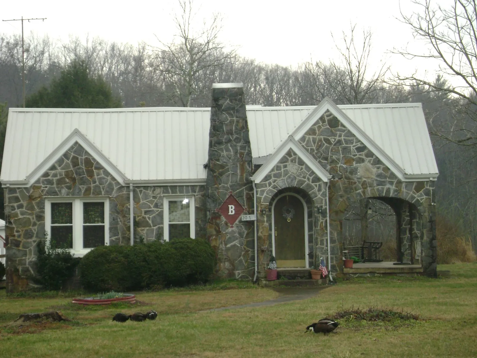 White metal roof on a stone cottage with steep gables in Susanville
